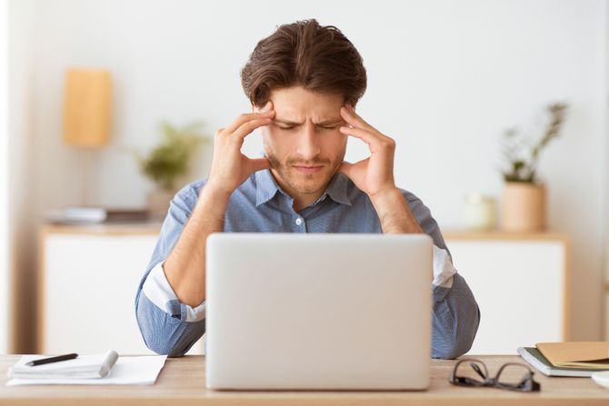 Rad od kuće, glavobolja, posaolaptop, stres, muškarac se drži za glavu Rad od kuće, glavobolja, posaolaptop, stres, muškarac se drži za glavu